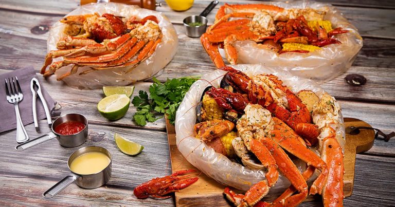 table with seafood displayed including crawfish, crab legs and shrimp